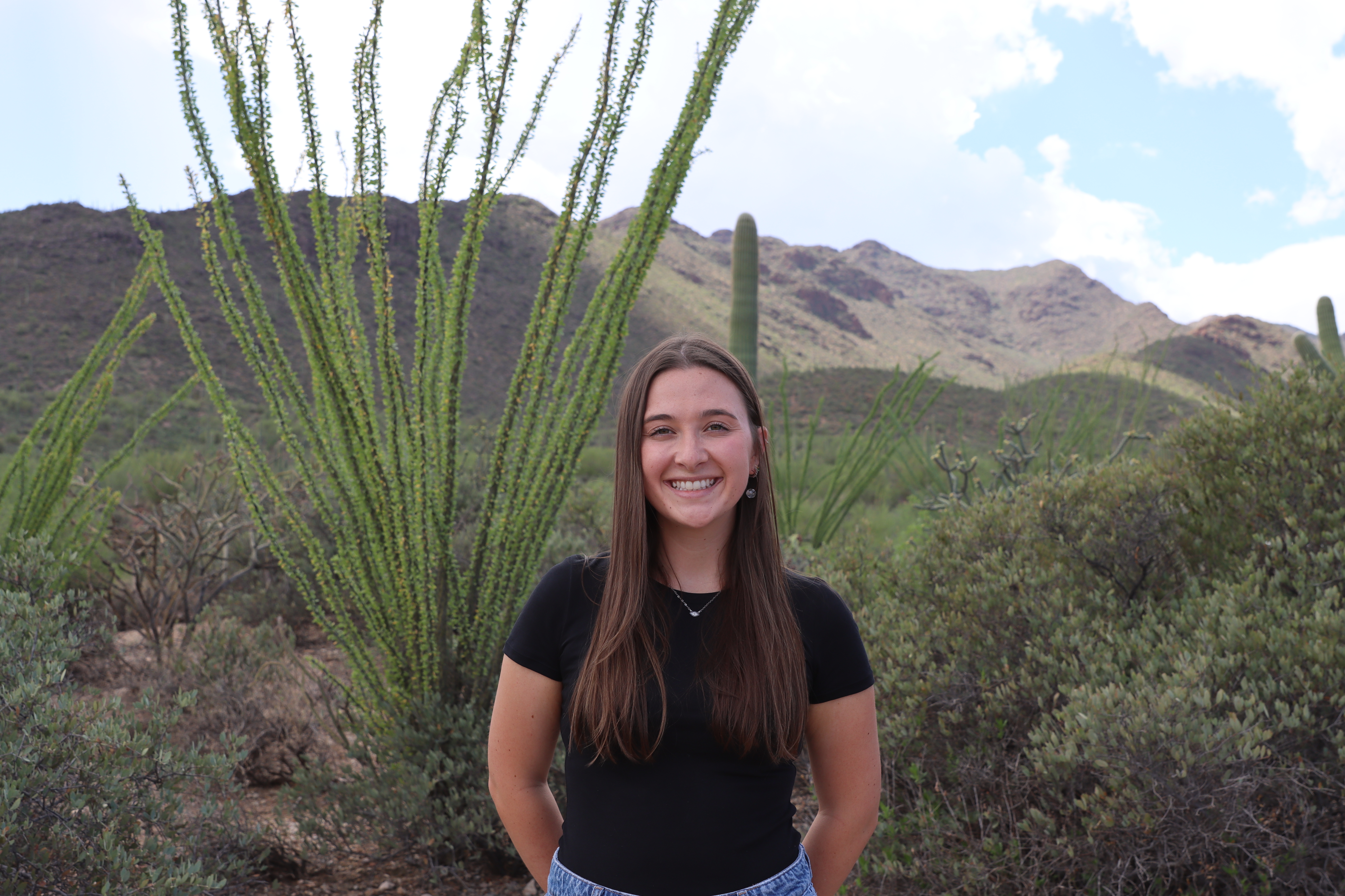 Rowan Cassarly standing outside in desert landscape under a sunny sky