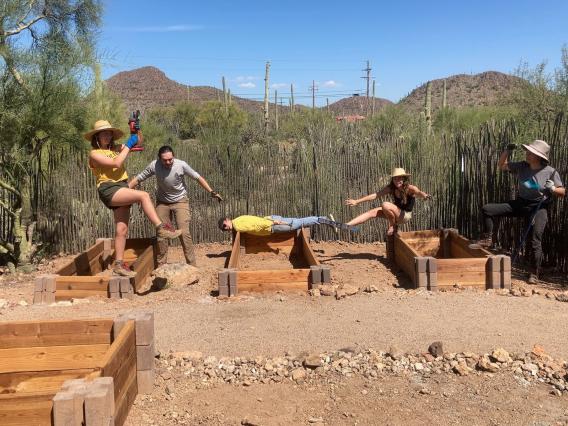 Compost Cats from the UA Office of Sustainability strike silly poses on empty raised garden beds at Camp Cooper.