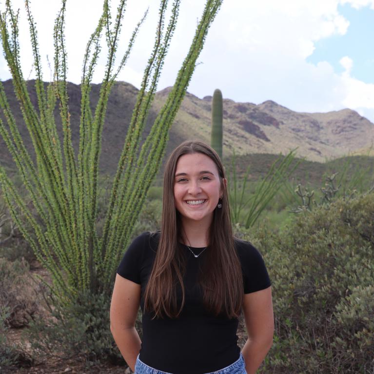 Rowan Cassarly standing outside in desert landscape under a sunny sky