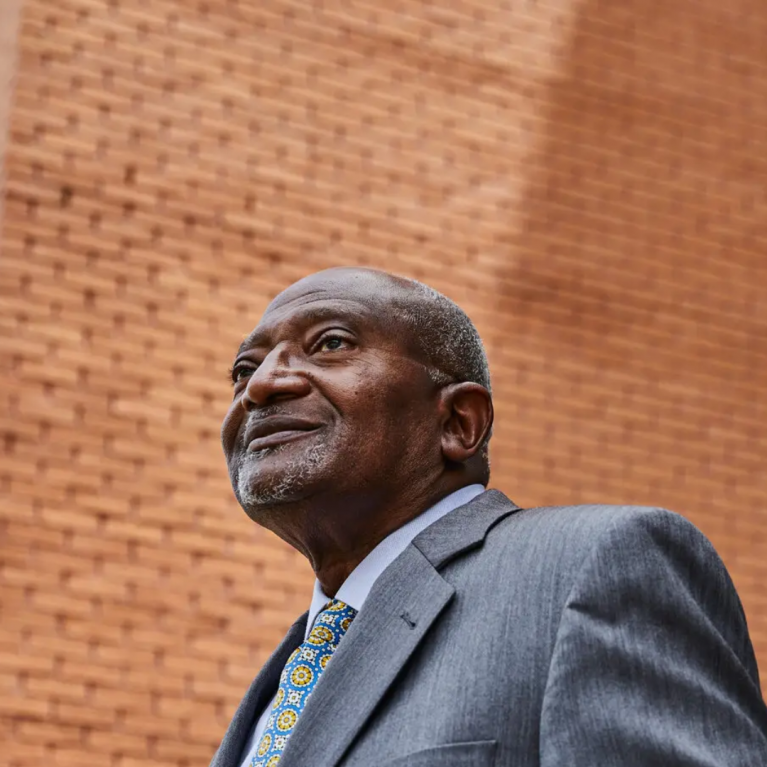 headshot of dr bullard with a brick pattern as a background